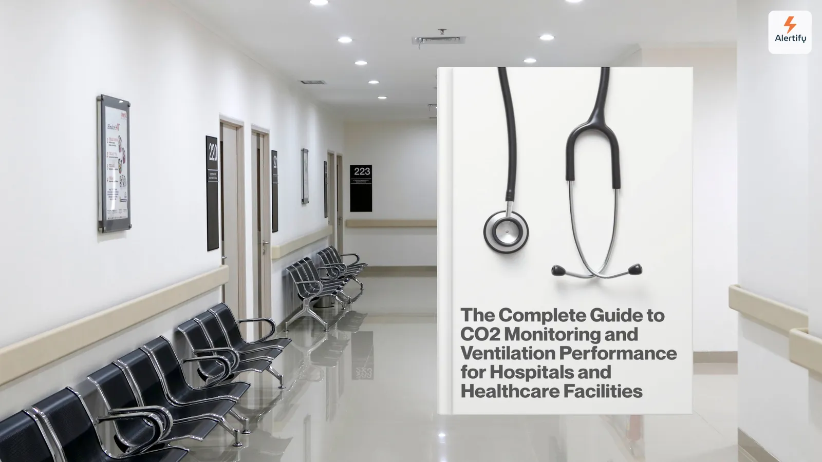 Empty hospital corridor with rows of waiting chairs beside a guide cover showing a stethoscope