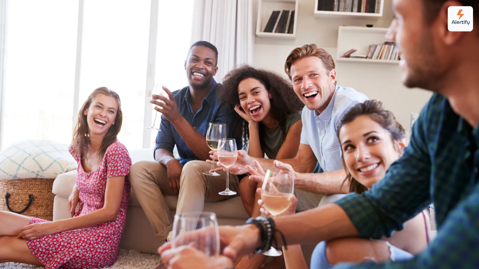 Group of friends laughing over glasses of wine in a vacation rental living room