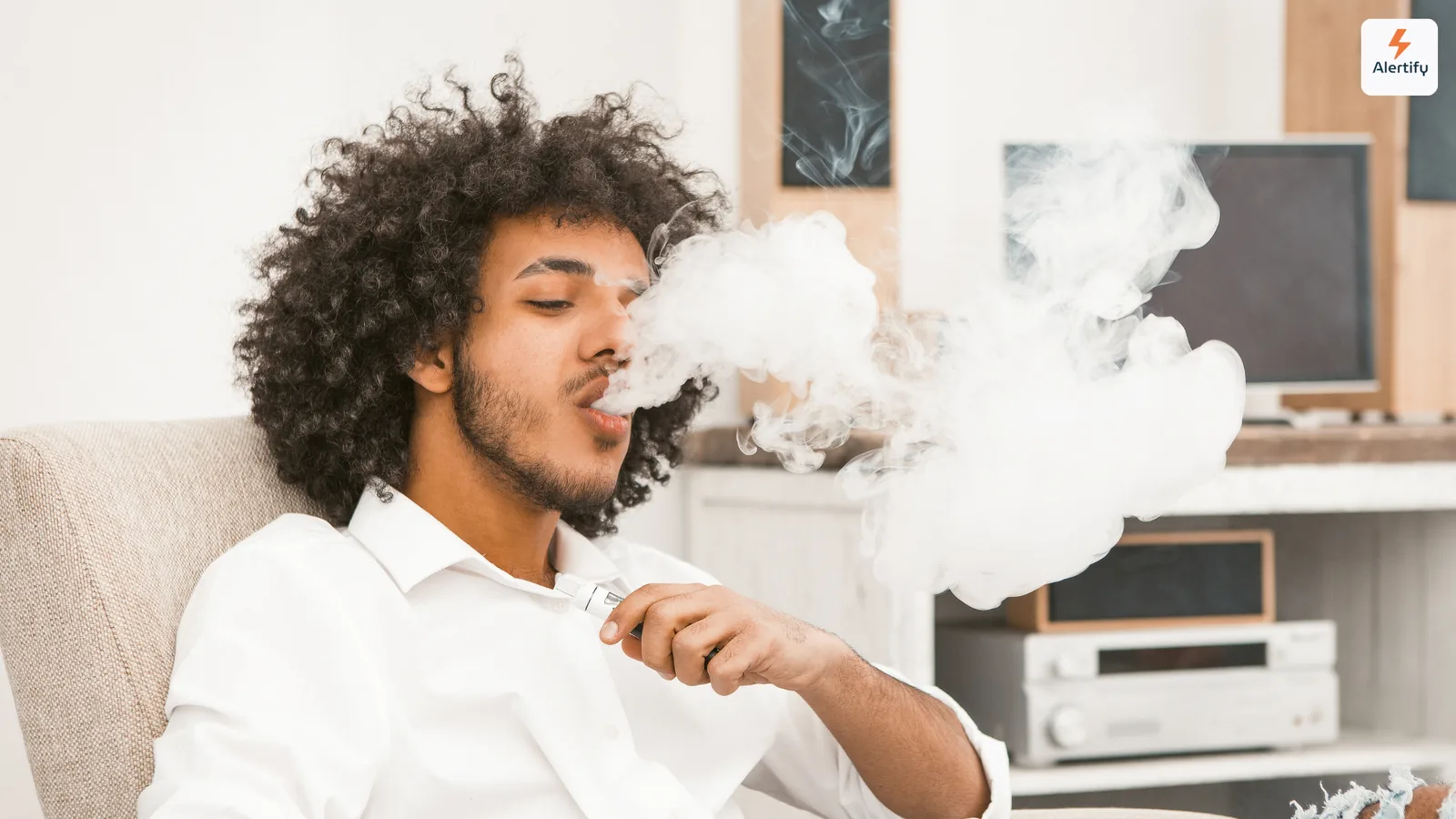 Guest exhaling a thick cloud of vapor while sitting in a vacation rental living room